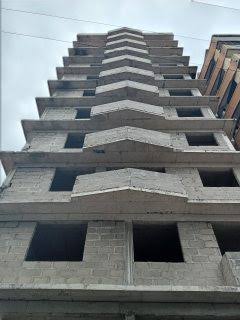 Tall unfinished building viewed from street level